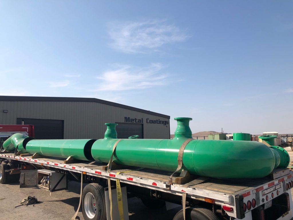 Large green painted spools on trailer